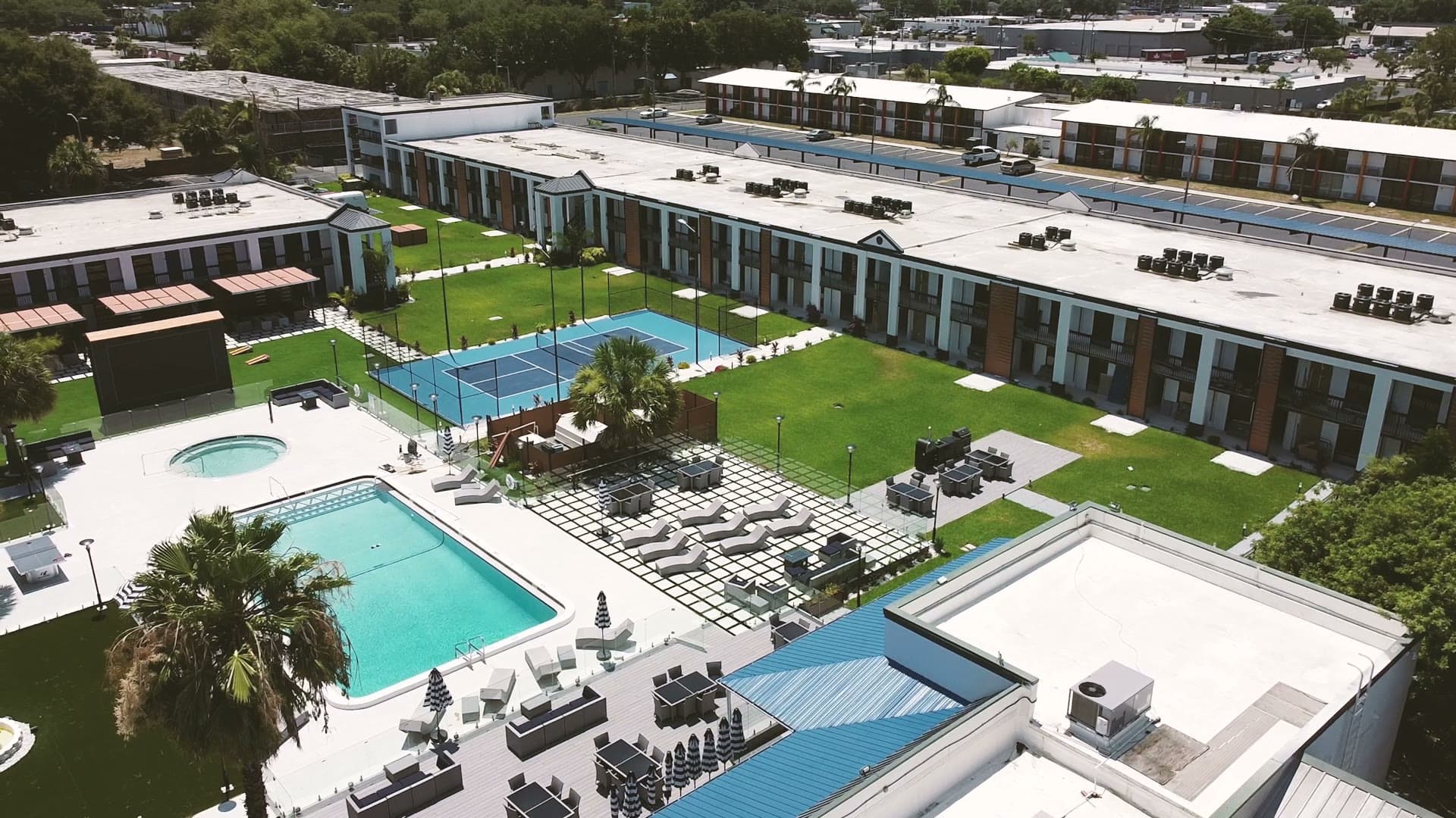 Aerial view of The Jade Winter Haven after conversion: the resort pool, spa and sport court in the amenity courtyard between the converted buildings